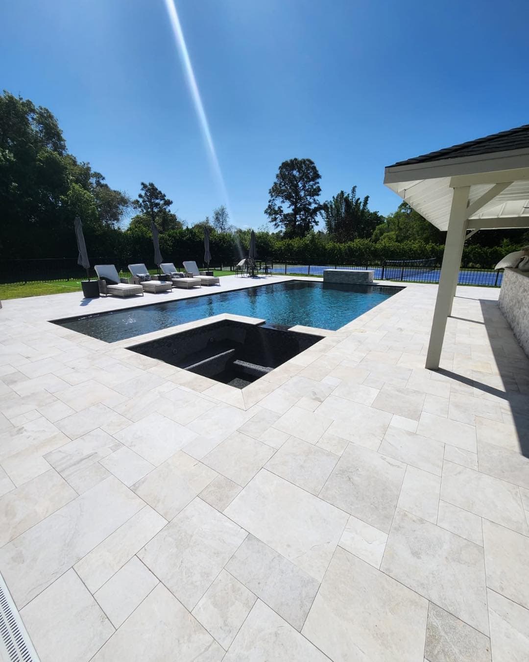 Luxury pool renovation with white travertine and spa